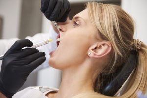 Stomatologist giving woman anesthesia in dentist's clinic