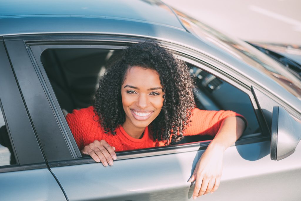 Young black woman sitting in the car smilling